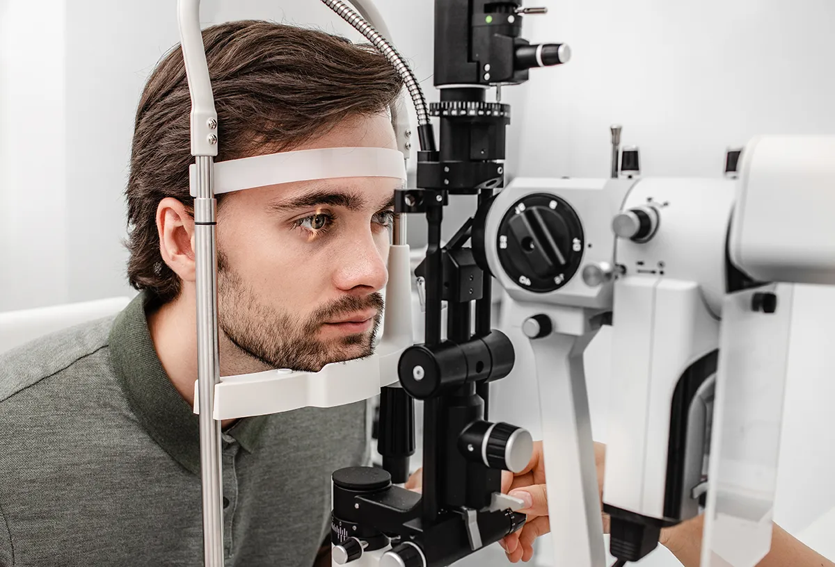 a young man getting an annual eye exam at the eye doctor's office