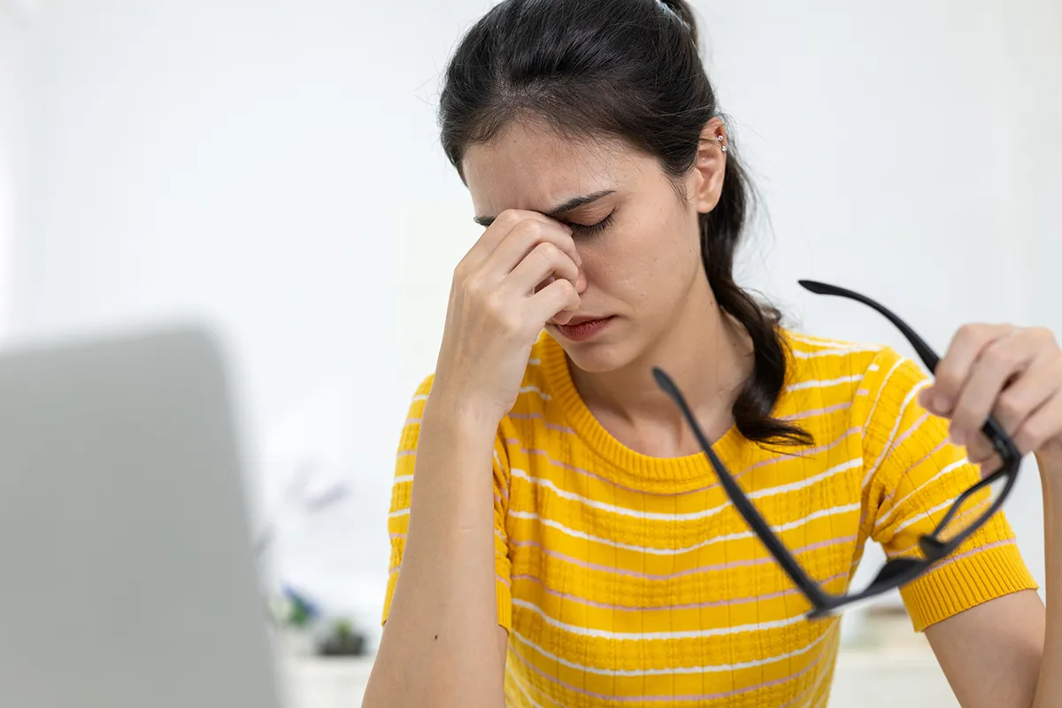 a woman suffering from eye strain while using a computer
