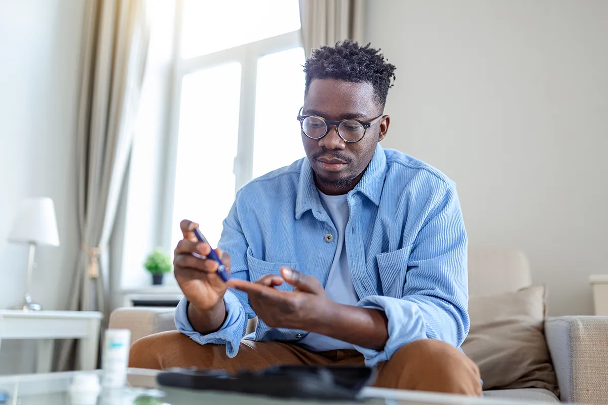a man using a glucose monitor at home