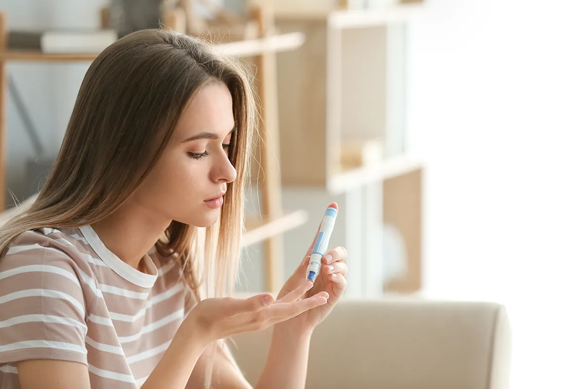 a diabetic woman checking her blood sugar at home